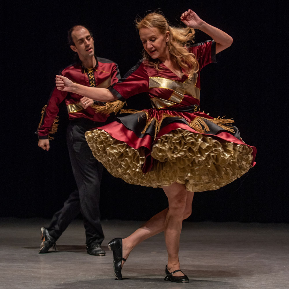 Two dance artists in traditional jigging clothing mid performance