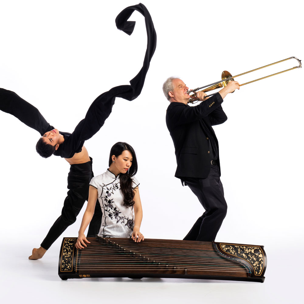 Dancer from Wen Wei Dance posing with two musicians from Turning Point Ensemble